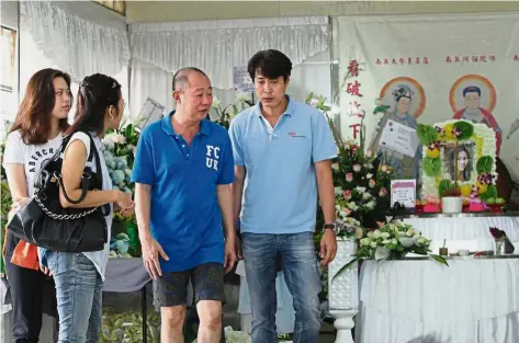  ??  ?? Sad farewell: Siak (in dark blue T-shirt), attending to visitors paying their respects during his wife’s wake at Batu Gantung funeral parlour in Penang.