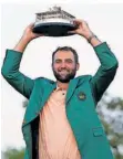  ?? FOTO: SLOCUM/AP/DPA ?? Golfprofi Scottie Scheffler hält die Siegertrop­häe für den Masters-Sieg in Augusta hoch.