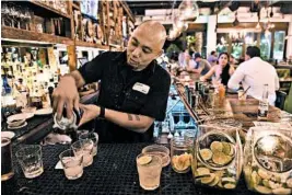  ??  ?? Bartender Nolan Collins mixes cocktails late at night at El Camino.