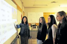  ?? ALLAN BENNER/STANDARD STAFF ?? Yan Zhao from Brock University's Confucius Institute discusses a Mandarin lesson with Sir Winston Churchill Secondary School students Taylor McRae, Kaiah Ing and Sarah Cameron.