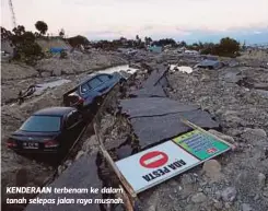  ??  ?? KENDERAAN terbenam ke dalam tanah selepas jalan raya musnah.