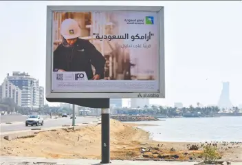  ?? RODNEY JEFFERSON/BLOOMBERG ?? Vehicles pass a billboard in Jeddah, Saudi Arabia, Friday advertisin­g the planned Aramco IPO. The Saudi government is seeking to drum up demand for the listing overseas as well.