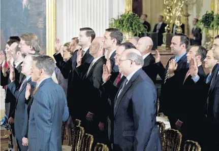  ?? POOL/GETTY IMAGES ?? White House senior staff members are sworn in by U.S. Vice President Mike Pence, not pictured, during a ceremony Sunday in the East Room of the White House. Later, in his first appearance in the White House’s East Room as president, Donald Trump...