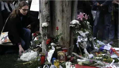  ?? ARIS MESSINIS/AFP/GETTY IMAGES ?? A memorial forms for a man who killed himself at Syntagma Square on Wednesday. His death struck a nerve with citizens of the troubled country.