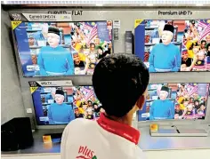 ??  ?? A member of the public watches the Budget 2018 announceme­nt. Budget 2018 is an inclusive budget, with measures laying the foundation for long-term and sustainabl­e growth. — Bernama photo