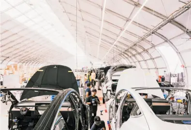  ?? Justin Kaneps / New York Times ?? Tesla Model 3s go through the assembly line at the factory in Fremont. The electric-car maker’s cash position was closely watched even before CEO Elon Musk, top, floated the idea of taking the company private.