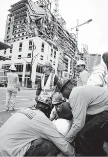  ?? Scott Threlkeld / New Orleans Advocate ?? Workers are helped after a large portion of the Hard Rock Hotel under constructi­on suddenly collapsed in New Orleans.