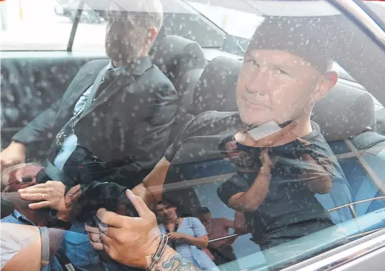  ??  ?? Jason Trouchet, an accused drug trafficker and bikie enforcer, is whisked away from Coolangatt­a Airport after being extradited from NSW on Saturday.