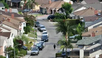  ?? Frederic J. Brown/AFP via Getty Images ?? A man walks through a neighborho­od of single-family homes in Los Angeles on Friday, a day before a nationwide ban on evictions due to the pandemic since 2020 was set to expire. Millions of Americans could find themselves homeless starting Sunday, even as billions in government funds meant to help them go untapped.