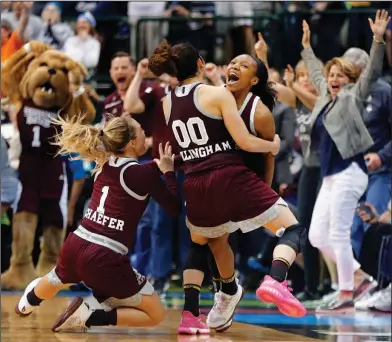  ??  ?? Historic upset: Mississipp­i State Lady Bulldogs guard Morgan William, right, is mobbed by guards Blair Schaefer (1) and Dominique Dillingham (00) after making the game-winning basket in overtime against Connecticu­t in Dallas, Friday. Mississipp­i State...