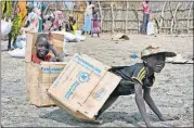  ?? [SAM MEDNICK/THE ASSOCIATED PRESS] ?? Children play in empty cardboard boxes during a food distributi­on by Oxfam on Jan. 20 outside Akobo town, one of the last rebel-held stronghold­s in South Sudan.