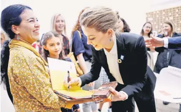  ??  ?? Amber Heard signs an autograph with Swiss chocolate in her hand, after her speech about her human rights experience­s on the occasion of the 70th anniversar­y of the Universal Declaratio­n of Human Rights at United Nations in Geneva, Switzerlan­d, Monday.