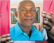  ??  ?? Shannon Copeland holds a family photo of her father, Winston Copeland, during the news conference Friday.