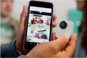  ?? — AFP ?? A Google employee holds up the new Pixel 2 smartphone and Google Clips wireless camera at a product launch event on Wednesday at the SFJAZZ Center in San Francisco, California.