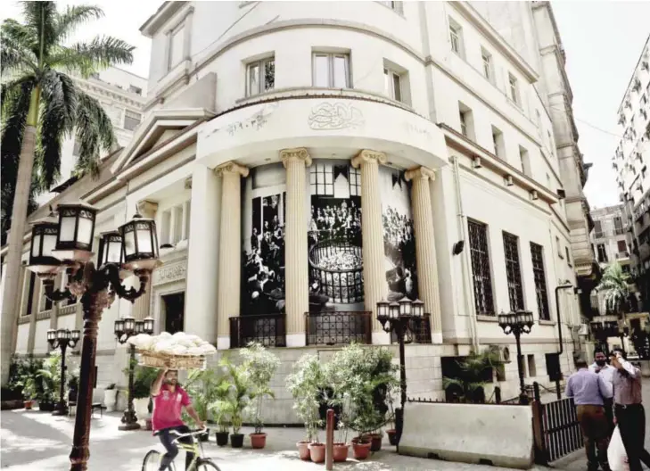  ?? — AP ?? CAIRO: Photo shows a man carrying bread bicycles past the stock market in downtown Cairo.