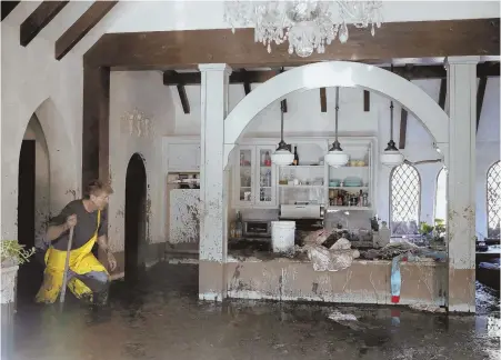  ?? APPhOTO ?? A DISASTER: Bill Asher walks through mud in his home damaged yesterday by storms in Montecito, Calif.