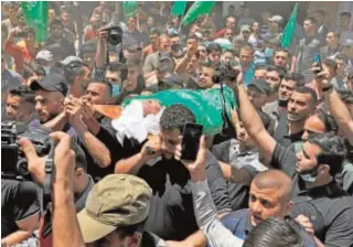  ?? AFP ?? Los palestinos llevan el cuerpo del jefe militar de Hamás Bassem Issa