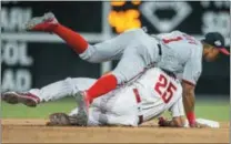 ?? LAURENCE KESTERSON — THE ASSOCIATED PRESS ?? The Phillies’ Dylan Cozens (25) is out at second base after Nationals shortstop Wilmer Difo (1) threw to first on a double play in the fourth inning Friday in Philadelph­ia. The Nationals beat the Phillies, 17-7.