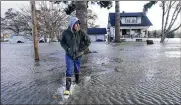  ?? ELAINE THOMPSON / ASSOCIATED PRESS ?? Benjamin Lopez steps from floodwater surroundin­g his parents’ home Monday in Sedro-woolley, Wash.