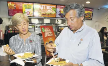  ??  ?? Denise Dubuque-lyn, chief operating officer, Island Grill, and Christophe­r Levy, president and CEO Jamaica Broilers Group, enjoying some of the excellent samples at yesterday’s official opening of Island Grill’s new restaurant in downtown Kingston.