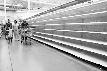  ??  ?? People walk past empty shelves where bread is normally sold in a Walmart store in advance of Hurricane Irma’s expected arrival in North Miami Beach, Florida, US, September 7. — Reuters photo