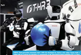  ??  ?? TOKYO: Third-generation humanoid robot T-HR3 (R) developed by Japan’s auto maker Toyota holds a rubber ball as it mirrors its operator’s (L) movements at the Internatio­nal Robot Exhibition 2017 in Tokyo yesterday.—AFP