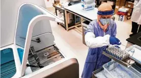  ?? Erin Schaff / New York Times ?? Potential specimens of the coronaviru­s are loaded into a Roche testing machine at a Quest Diagnostic­s facility in Chantilly, Va., on April 8.