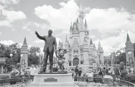  ?? ALLIE GOULDING/TAMPA BAY TIMES 2019 ?? The “Partners” statue sits in front of Cinderella’s Castle at Disney World’s Magic Kingdom in Orlando, Florida.