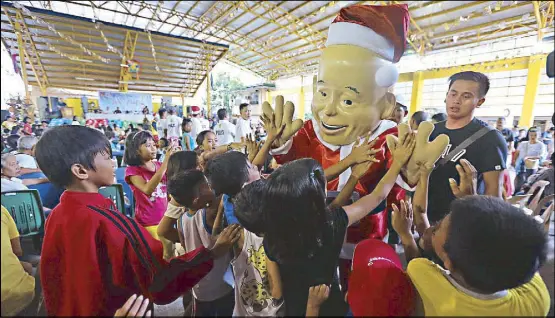  ?? BOY SANTOS ?? PNP chief Director General Ronald dela Rosa’s mascot, PO1 Bato, entertains the children of drug offenders during a Christmas party at the Batasan High School in Quezon City yesterday.