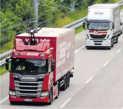  ?? BILD: Marcus Brandt ?? Bei Reinfeld In Holstein: Ein Hybridlast­er der Spedition Bode (vorne, rot) fährt über die EHighway-Teststreck­e auf der Autobahn 1 zwischen Reinfeld und Lübeck.