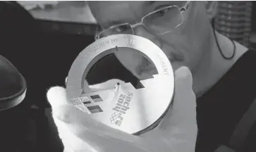  ?? KIRILL KUDRYAVTSE­V/AFP/GETTY IMAGES ?? An employee works on a medal for the 2014 Winter Olympic Games in Sochi, at the Adamas jewelry factory in Moscow. The factory is the official medal supplier of the 2014 Winter Olympic and Paralympic Games in Sochi.