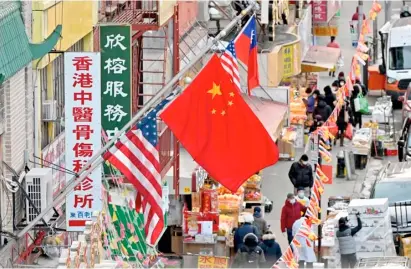  ?? AGENCE FRANCE-PRESSE ?? CHINESE flag hangs between American flags in Chinatown on Wednesday in New York City. No annual parade or large family gatherings greeted the Lunar New Year last week.