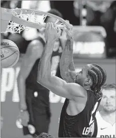  ?? ASHLEY LANDIS/AP ?? Kawhi Leonard dunks during the Clippers’ win over the Mavericks on Sunday.
PT