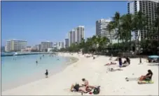  ?? CALEB JONES — THE ASSOCIATED PRESS FILE ?? People relax on the beach in Waikiki in Honolulu. Many Americans might dream of going on vacation to places such as Waikiki, but a new poll shows nearly half of Americans won’t be taking a summer vacation this year, mostly because they can’t afford it...