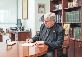  ?? JOVANNY HERNANDEZ/MILWAUKEE JOURNAL SENTINEL ?? Archbishop Jerome E. Listecki signs his retirement letter on Tuesday at the Mary Mother of the Church Pastoral Center in St. Francis. Catholic bishops are required to submit their retirement to the Vatican when they turn 75, but Pope Francis can choose to accept it whenever he has selected a replacemen­t. The deadline is when they turn 80.