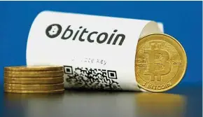  ??  ?? Deals under scrutiny: A bitcoin (virtual currency) paper wallet with QR codes and a coin are seen in an illustrati­on picture shot. The SEC says companies issuing ICOs must register the deals with the government unless they have a valid excuse. — Reuters