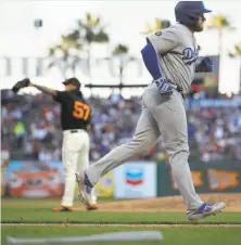  ?? Ben Margot / Associated Press ?? The Dodgers’ Max Muncy runs to first base after being walked by Giants reliever Dereck Rodriguez with the bases loaded.
