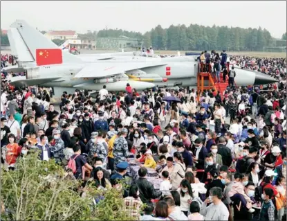  ?? LI ZHONG / FOR CHINA DAILY ?? A JH-7 fighter-bomber draws crowds during an open day at a People’s Liberation Army Air Force base in Hangzhou, Zhejiang province, on Nov 7. Residents were invited to visit the airfield to celebrate the 71st anniversar­y of the founding of the Air Force.