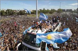  ?? RODRIGO ABD / AP ?? The Argentine soccer team that won the World Cup title ride on top of an open bus during their homecoming parade in Buenos Aires, Argentina on Tuesday.