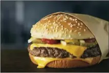 ?? COURTESY OF MCDONALD’S CORPORATIO­N VIA AP ?? This image provided by McDonald’s Corp. shows a Quarter Pounder burger. McDonald’s says it will swap frozen beef patties for fresh ones in its Quarter Pounder burgers by sometime in 2018 at most of its U.S. locations. Employees will cook up the...
