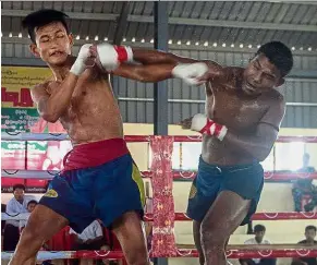  ?? — AFP ?? Contact point: Boxing exponents Soe Oo (left) and Naing Lin Tun exchanging blows during the Lethwei competitio­n marking Armed Forces Day in the town of Maungdaw in Rakhine state. The bout ended in a draw.
