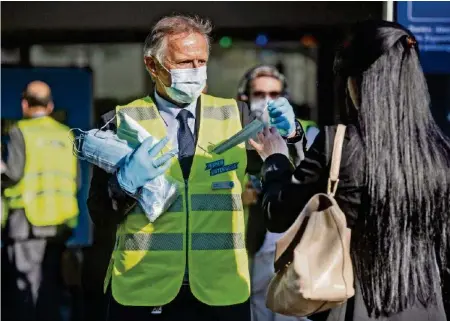  ?? KEYSTONE ?? Die Mitarbeite­r der VBZ gingen selbst auf die Strasse, um die Hygienemas­ken an ihre Kunden zu verteilen.