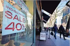  ??  ?? compradore­s pasan frente a una tienda Indigo que ofrece descuentos hasta de 40%