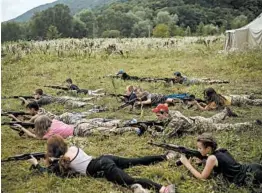  ?? FELIPE DANA/AP ?? Youngsters aim their AK-47s during a tactical exercise at a camp near Ternopil, Ukraine.