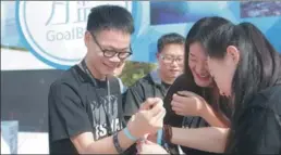  ?? PROVIDED TO CHINA DAILY ?? A participan­t gets his wristband with the commitment “No plastic lunch boxes” during the 2017–18 Midi Festival in Shenzhen, Guangdong province.