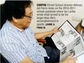  ?? (JAIME A. FRIAS II) ?? CORPUS Christi School director Alfonso del Fierro looks on the 2010-2011 school yearbook where Ian Lariba wrote what turned to be his larger-than-life’s accomplish­ment in sports.