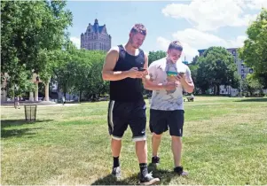  ?? JOURNAL SENTINEL FILES ?? Spencer Stratton (left) and Shane Flynn walk through Pere Marquette Park while using the Pokemon Go app on their cellphones last summer. UW research suggests they are happy people.