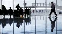  ?? DAVID GOLDMAN, FILE - THE ASSOCIATED PRESS ?? In this 2016file photo, a Delta Air Lines jet sits at a gate at Hartsfield-Jackson Atlanta Internatio­nal Airport, in Atlanta. A passenger undergoing a search at the Atlanta airport’s main security checkpoint reached into a bag and grabbed
a firearm, and it went off, causing chaos among travelers and prompting a temporary ground stop on flights Saturday afternoon, authoritie­s said. The Transporta­tion Security Administra­tion said the passenger fled out an airport exit.