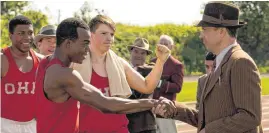  ??  ?? Stephan James, center, as Jesse Owens, and Jason Sudeikis, right, as Larry Snyder, star in Stephen Hopkins’ “Race.”