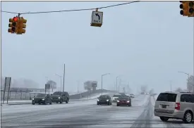  ?? PEG MCNICHOL — MEDIANEWS GROUP ?? Drivers navigate snowy and icy conditions on North Perry Street in Pontiac on Feb. 28.